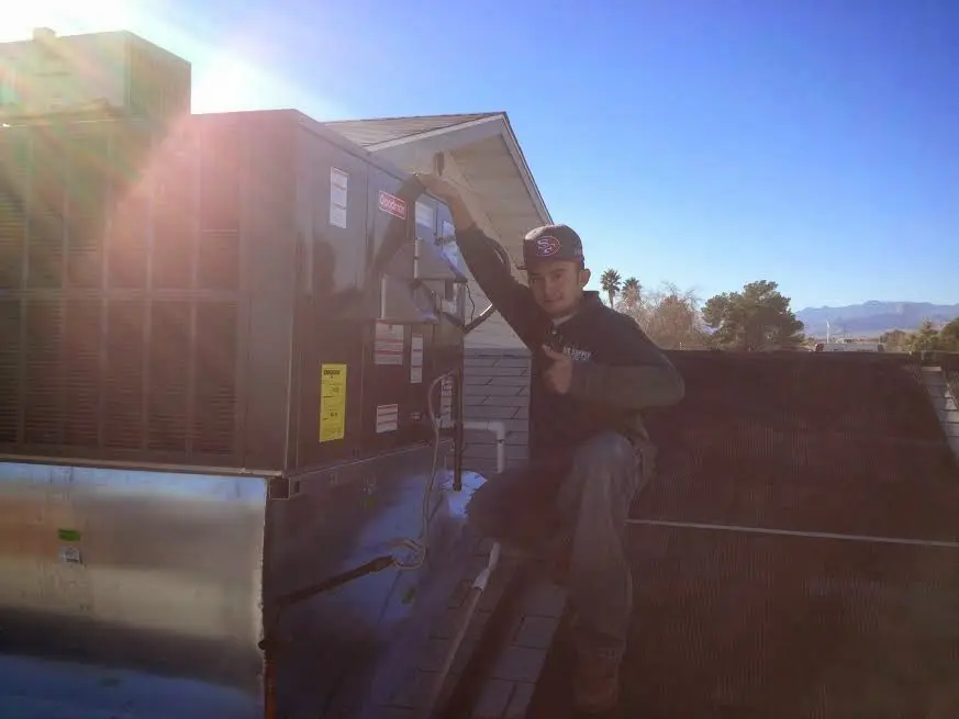 HVAC technician performing Heat Pump Repair on a rooftop unit in O'Fallon